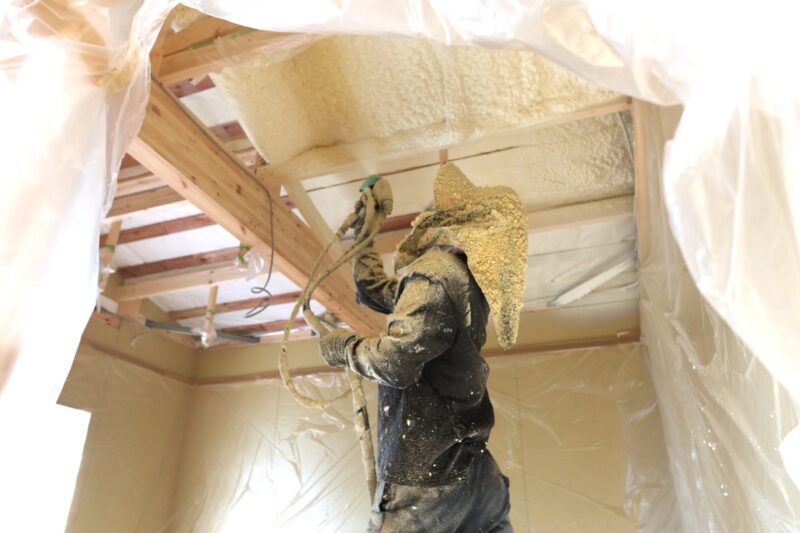 屋根下に断熱材を吹き付ける様子